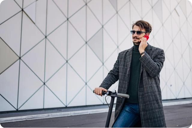 een man aan de telefoon met zijn scooter